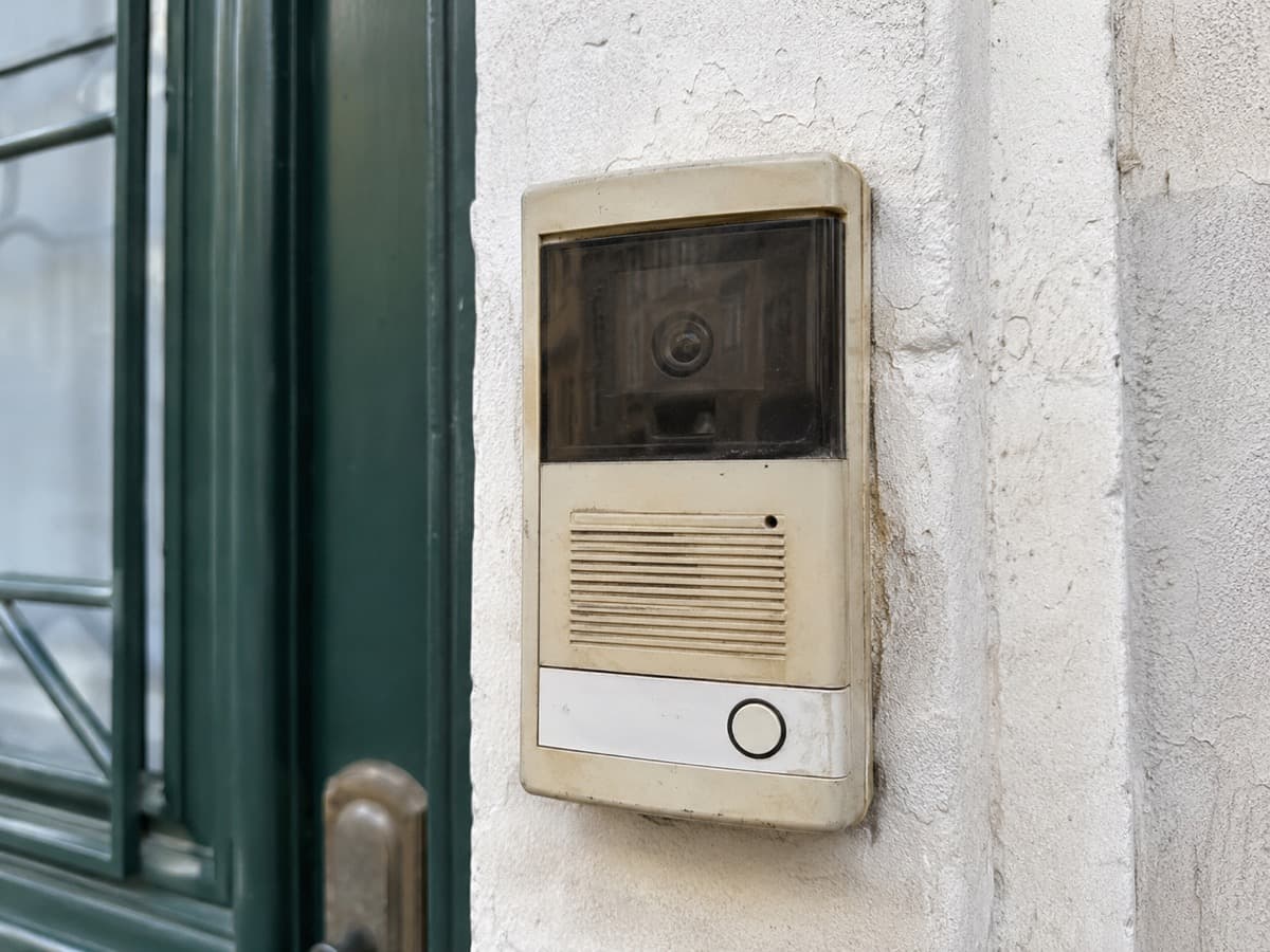 Verouderd intercom-paneel aan een voordeur, toe aan vervanging door een modern systeem