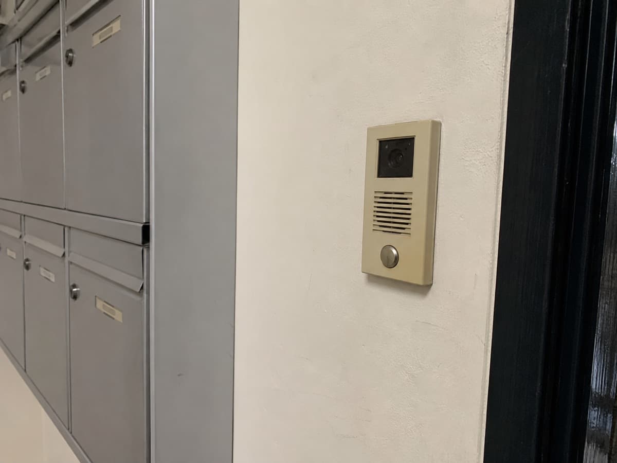 Verouderd intercom-paneel bij de entree van een appartementencomplex, toe aan vervanging door een modern systeem