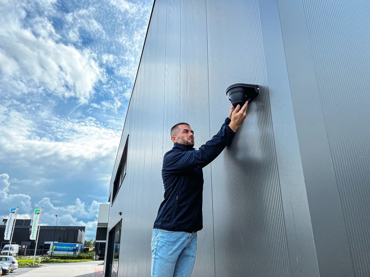 Securetech-monteur stelt een premium dome-camera af op een modern bedrijfspand