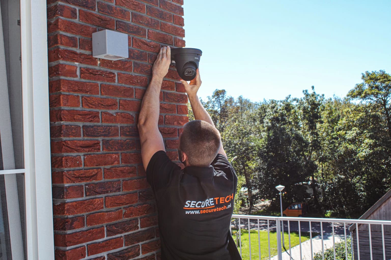 Securetech monteur installeert dome camera bij VvE-complex