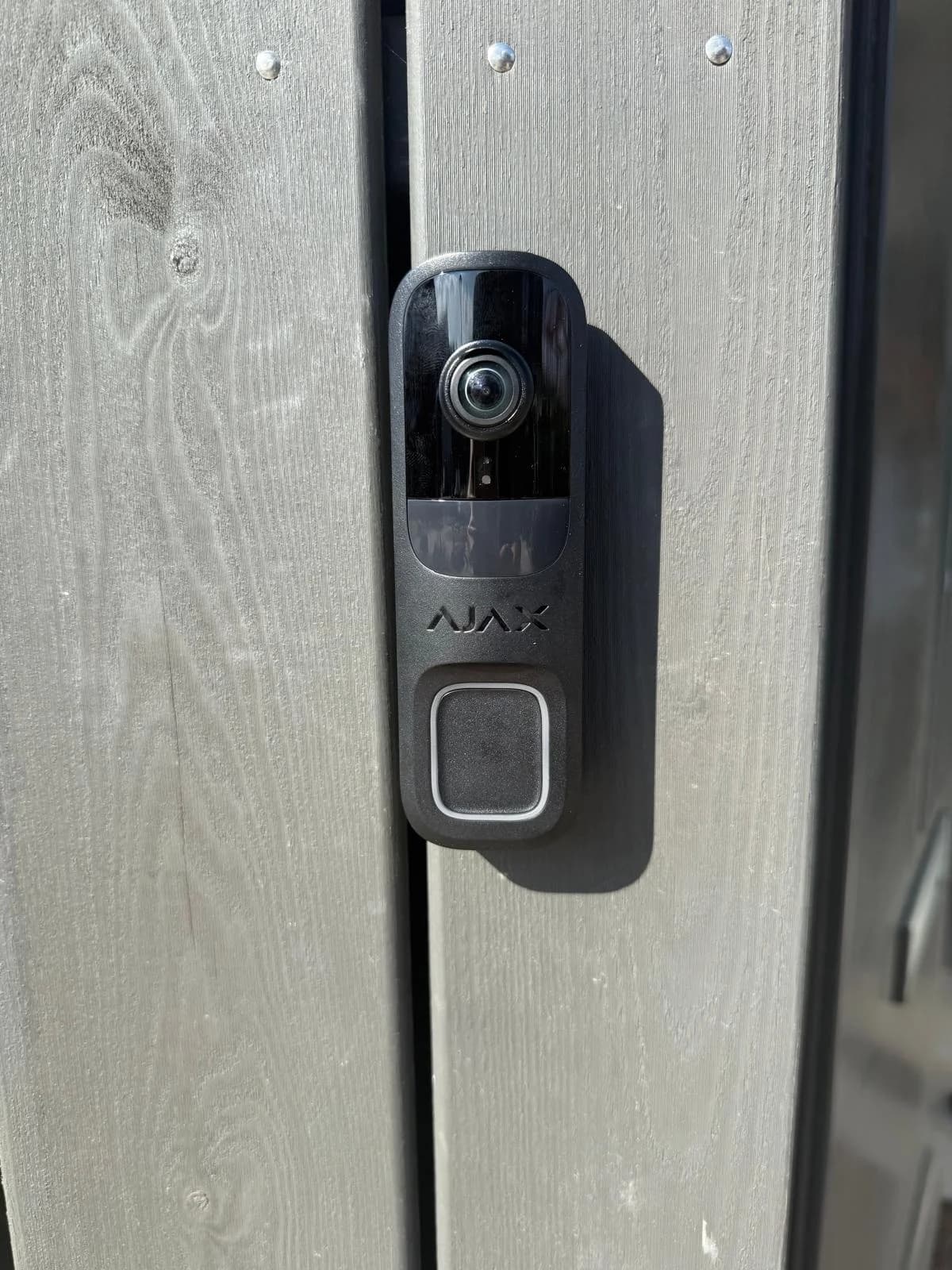 Close-up Ajax video-deurbel met wide-angle lens op houten gevel woning Almere, installatie Securetech