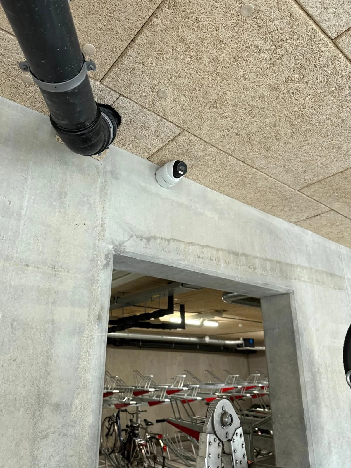 Camera boven doorgang naar fietsenstalling in betonnen VvE-kelder Rotterdam door Securetech