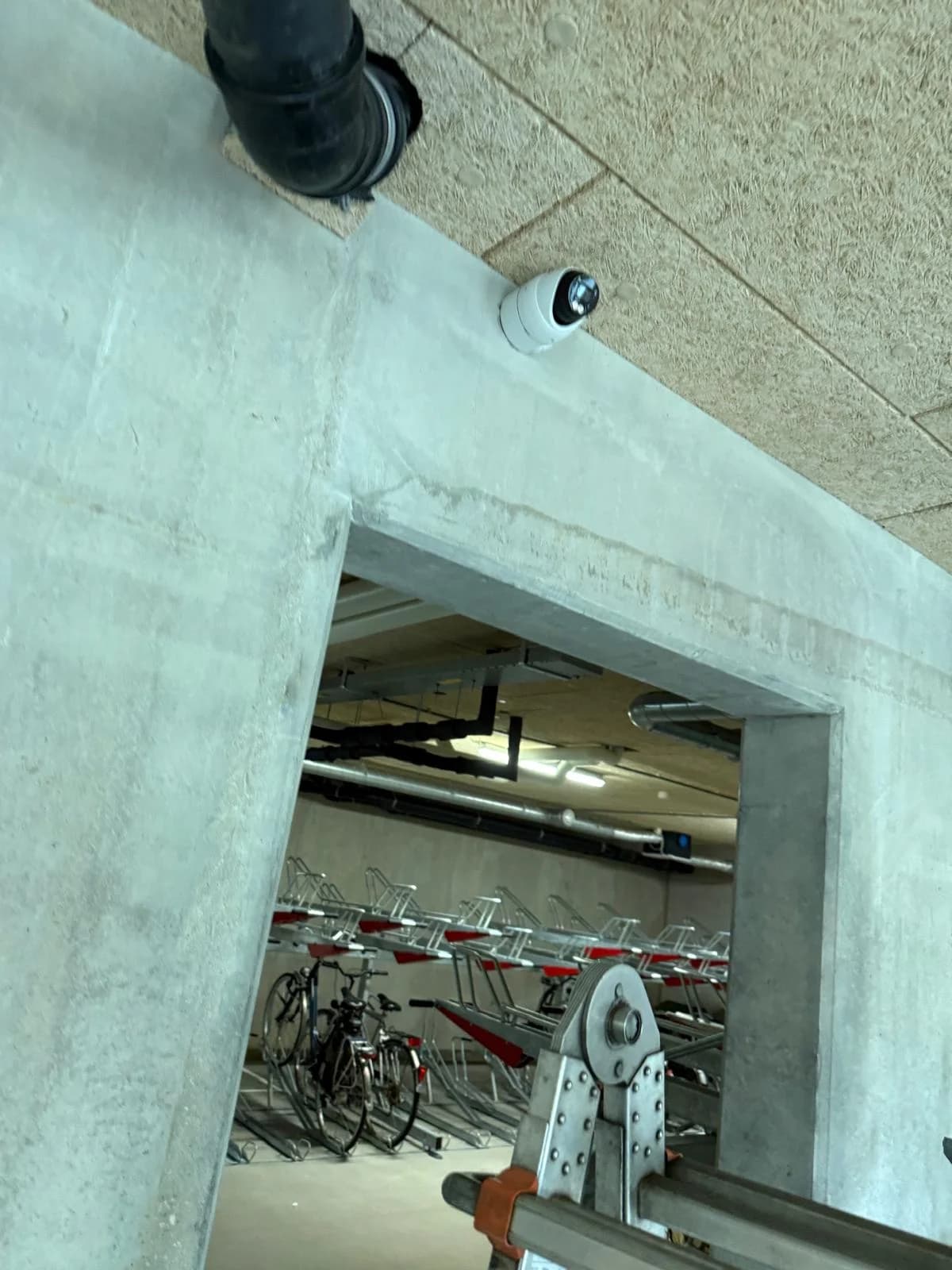Dome camera bij ingang fietsenstalling met fietsenrekken in zicht, VvE Alexliving Rotterdam