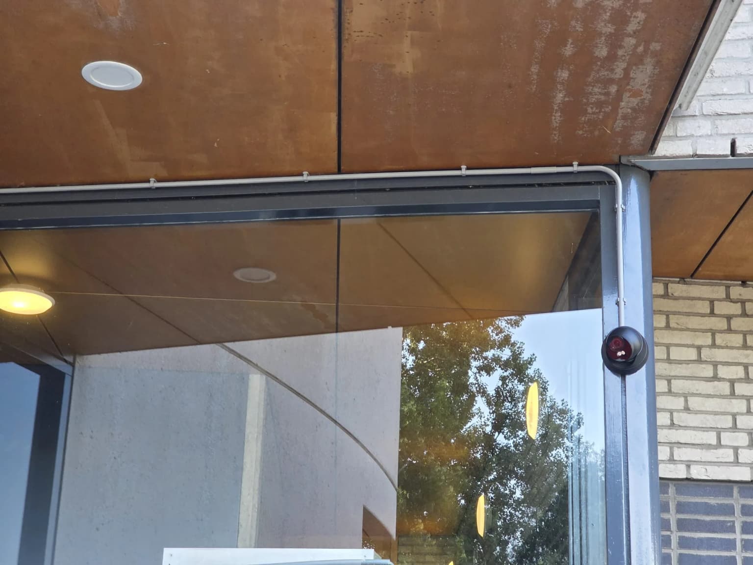 Dome-camera bij de entree van het VvE-complex in Den Haag, met de bekabeling netjes weggewerkt langs het plafond