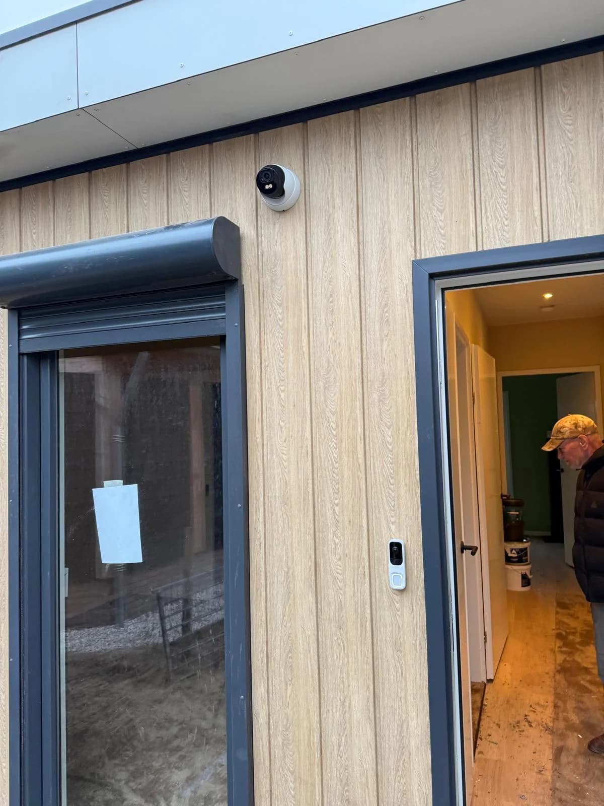 4K camera naast voordeur met Ajax deurbel op houtlook gevel van woning Wagenberg