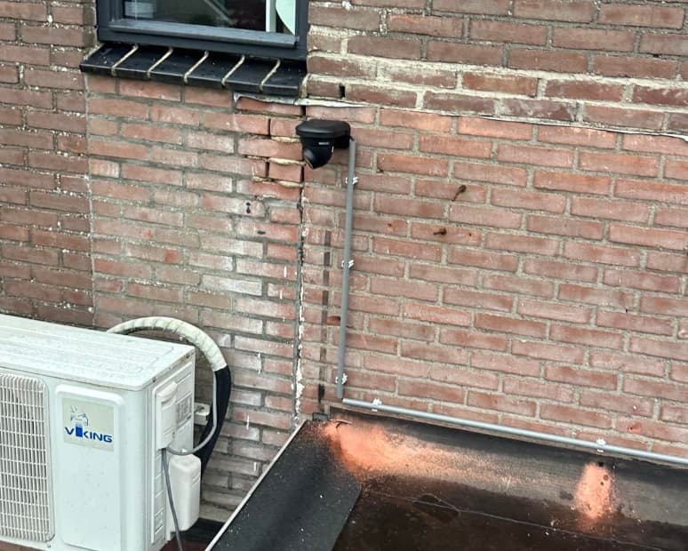 Camera op hoek gevel woning Wervershoof naast warmtepomp