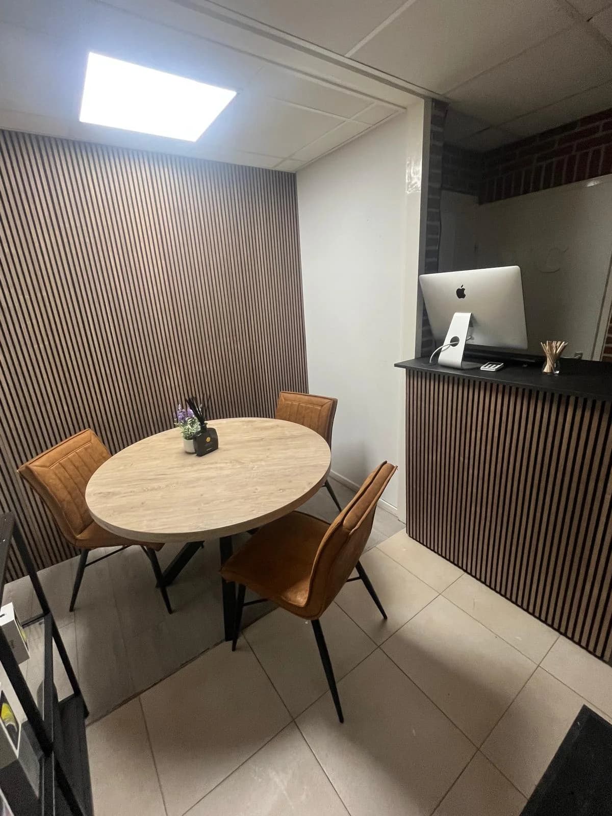 Intake-ruimte van Zapfix met iMac en klanttafel, gemonitord door camerasysteem