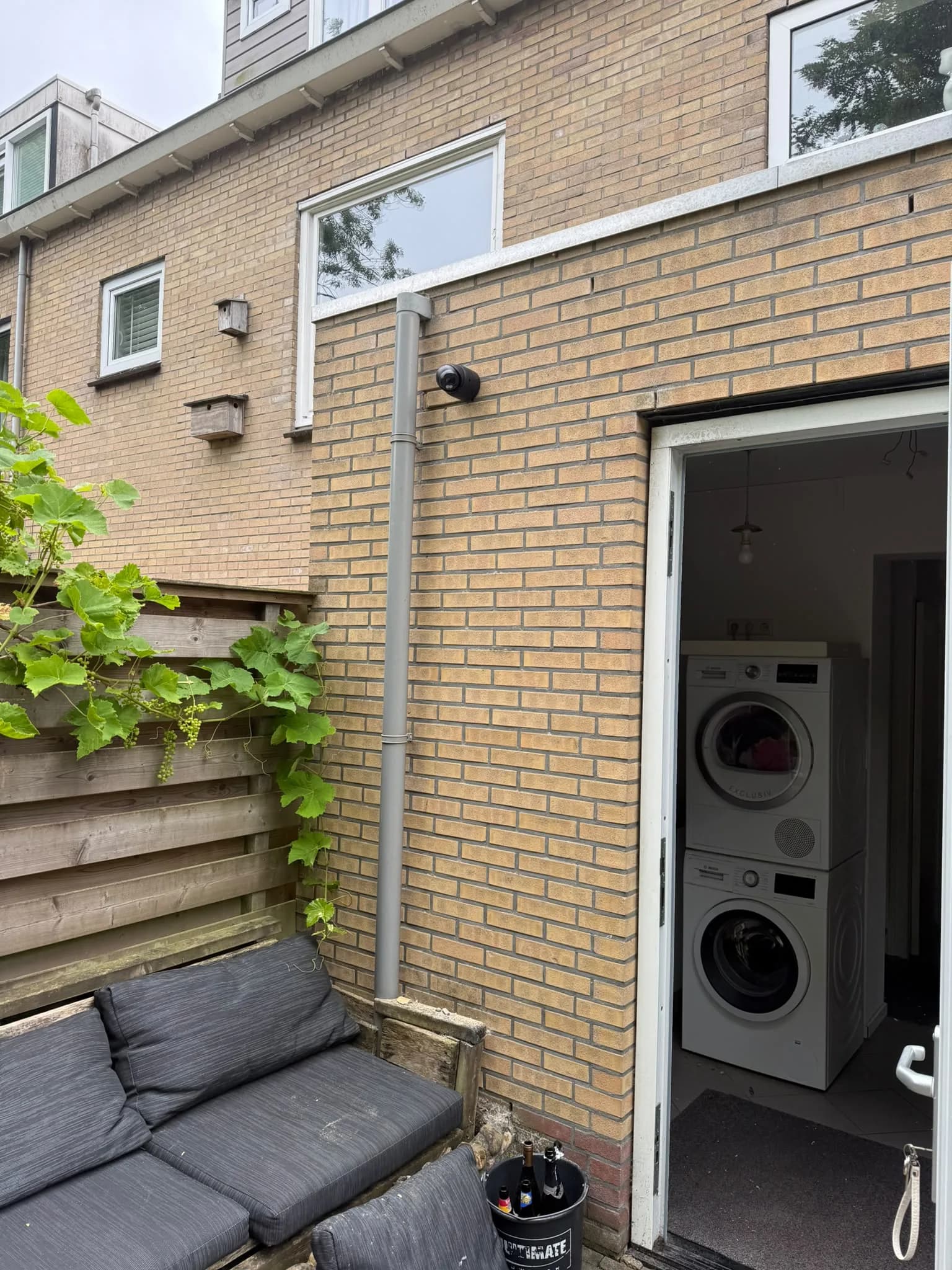 Dome-camera aan de achterzijde van hetzelfde pand in Heerhugowaard, gemonteerd op de regenpijp met zicht op de tuin