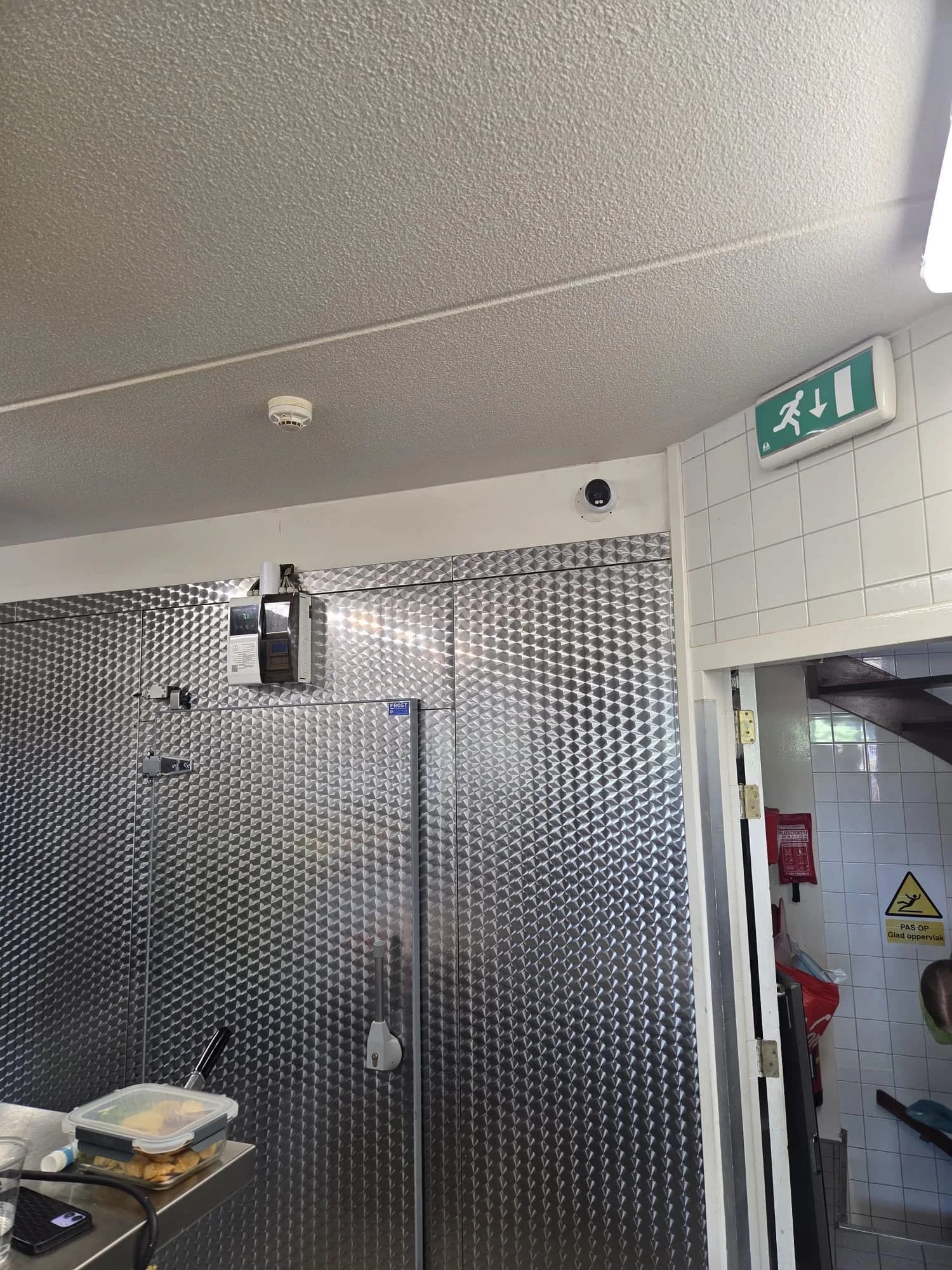 Dome-camera in de achterkeuken van de cafetaria, bij de koelcel en de nooduitgang