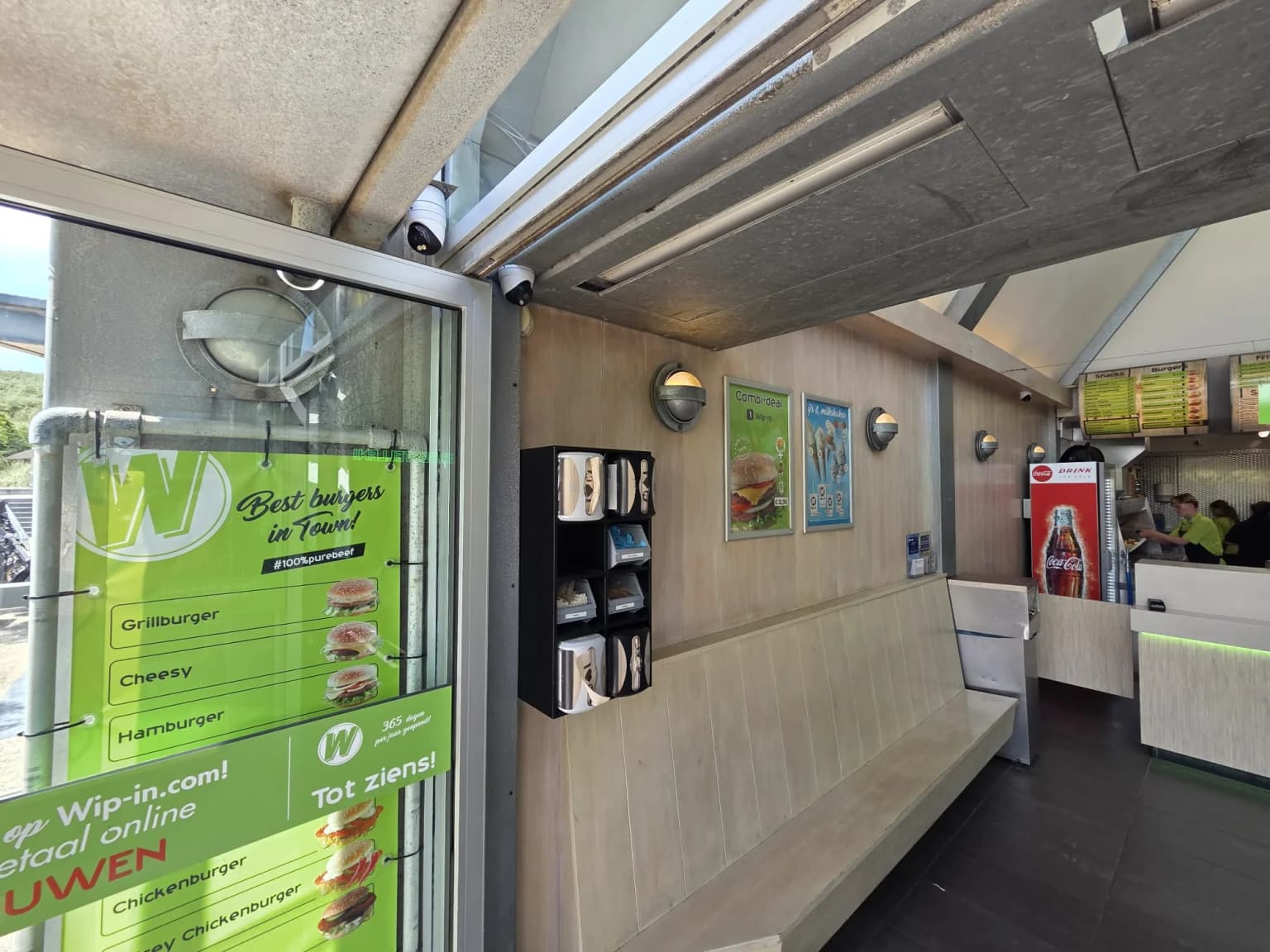 Twee dome-camera's onder de overkapping bij de zitgelegenheid en de bestelbalie van de cafetaria in Callantsoog