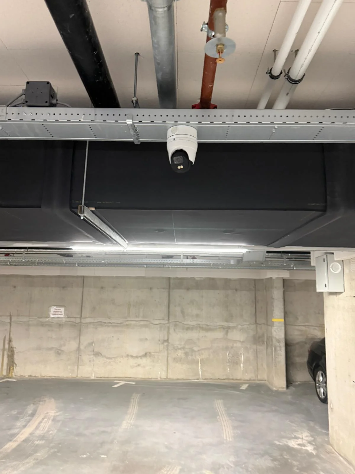 4K dome camera naast zwart luchtkanaal in parkeergarage Nottinghill, installatie Securetech
