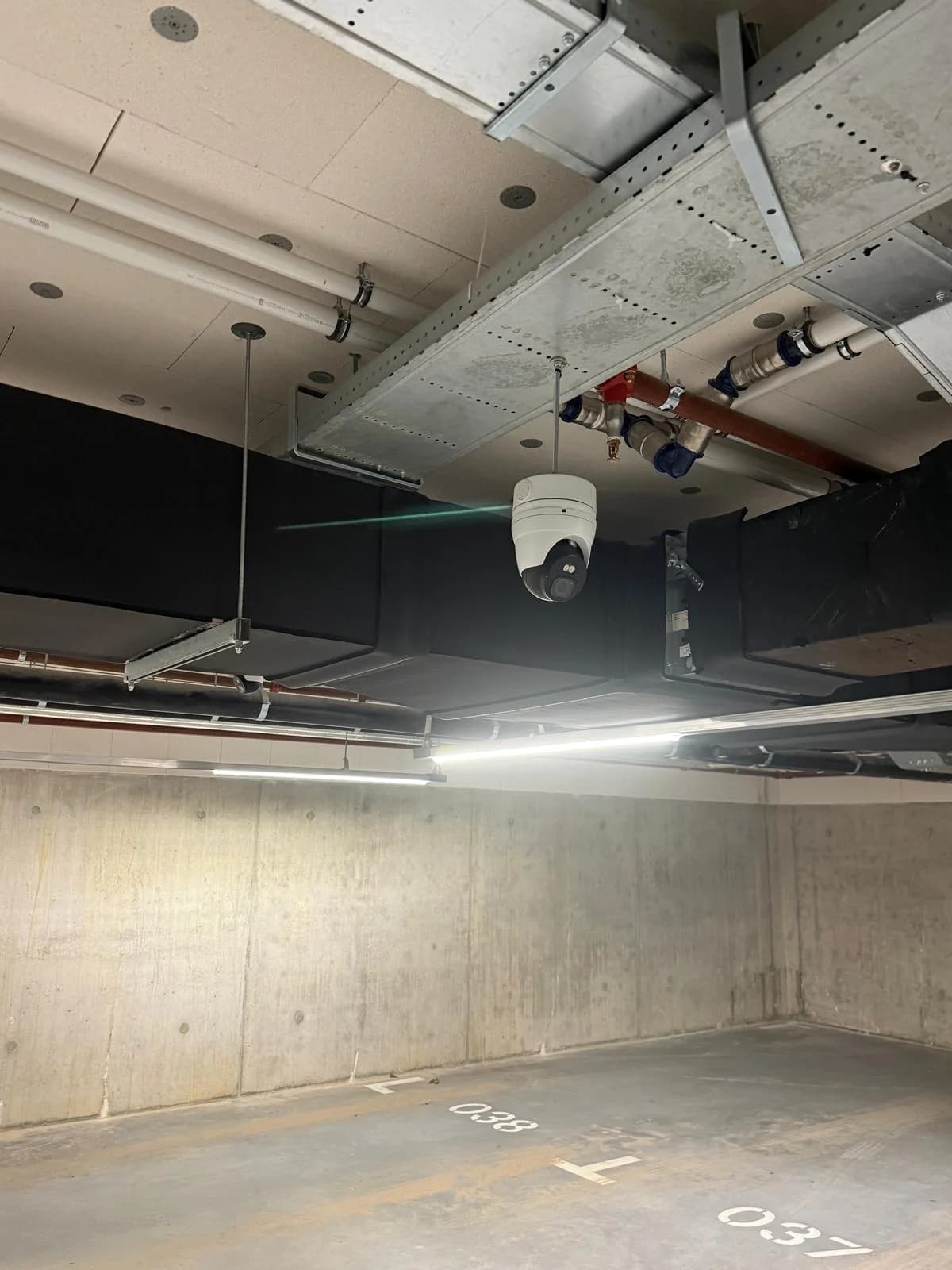 Dome camera in installatierail aan plafond betonnen parkeerkelder Nottinghill