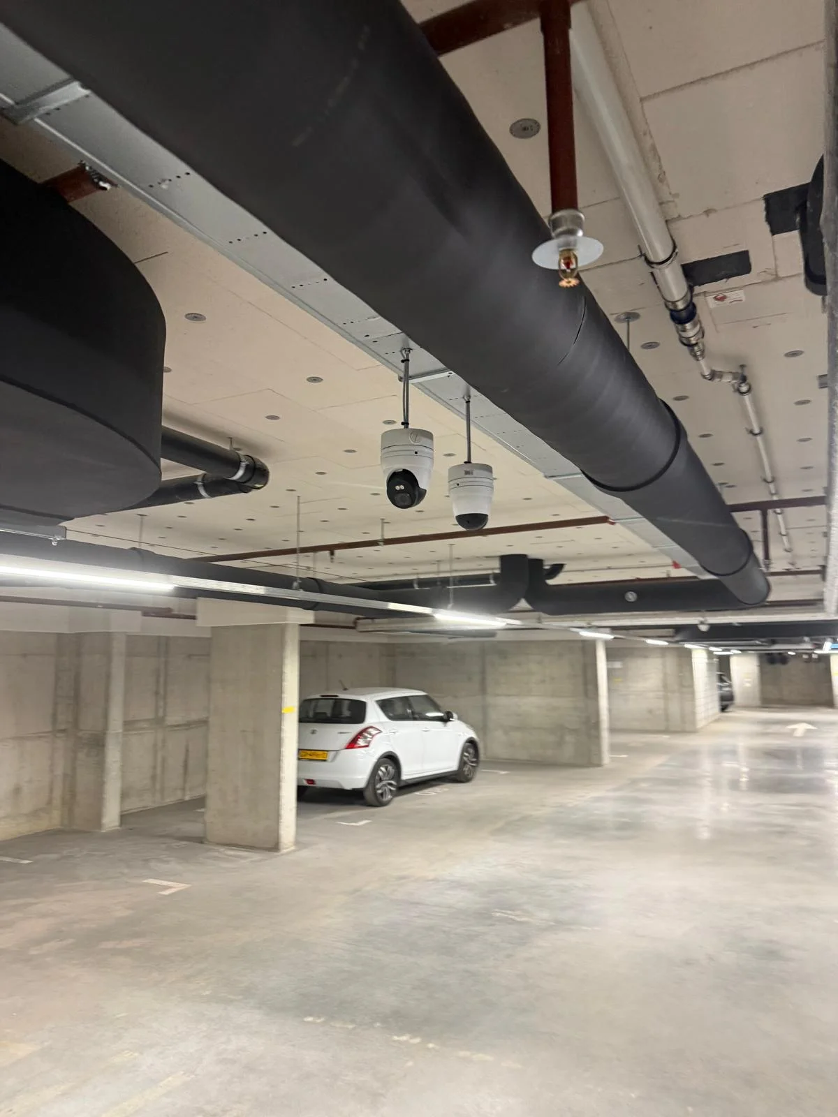 Twee 4K camera's (dome + PTZ) aan plafond parkeergarage Nottinghill Hoofddorp door Securetech