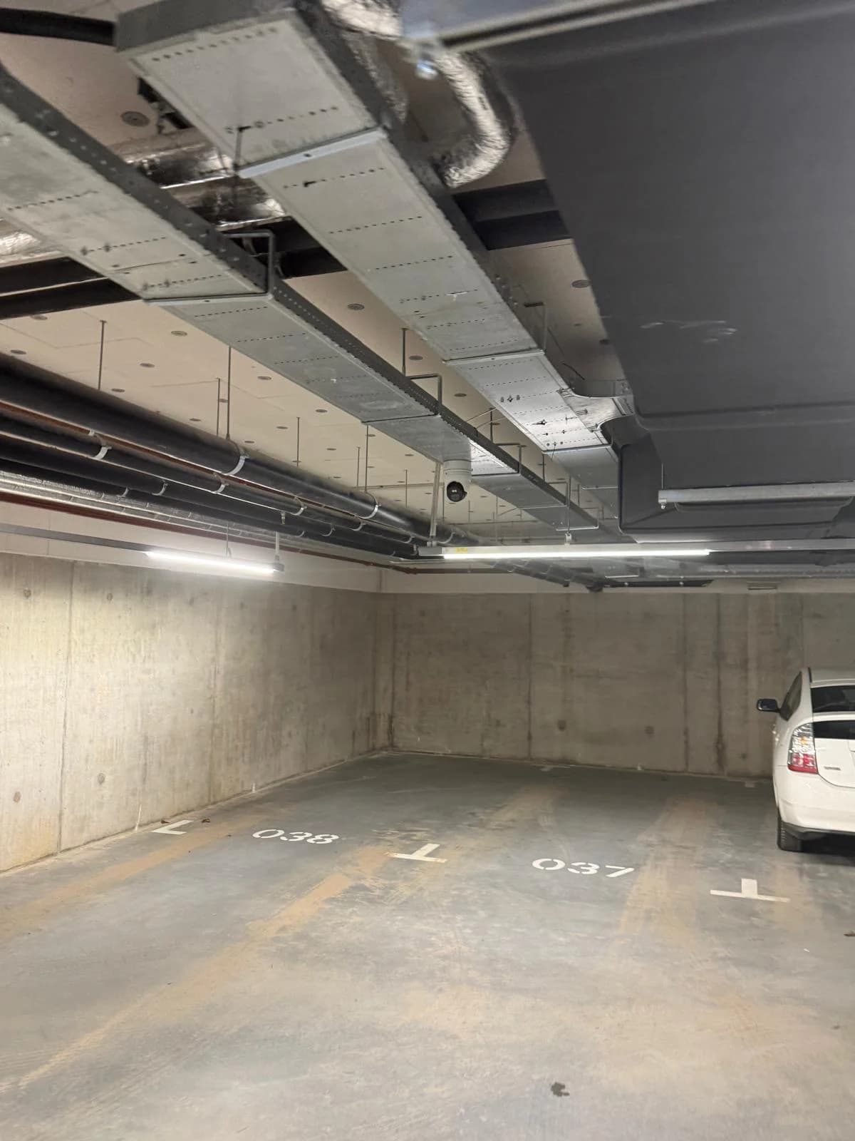 Overzicht plafond parkeergarage Nottinghill met camera-installatie en genummerde parkeervakken