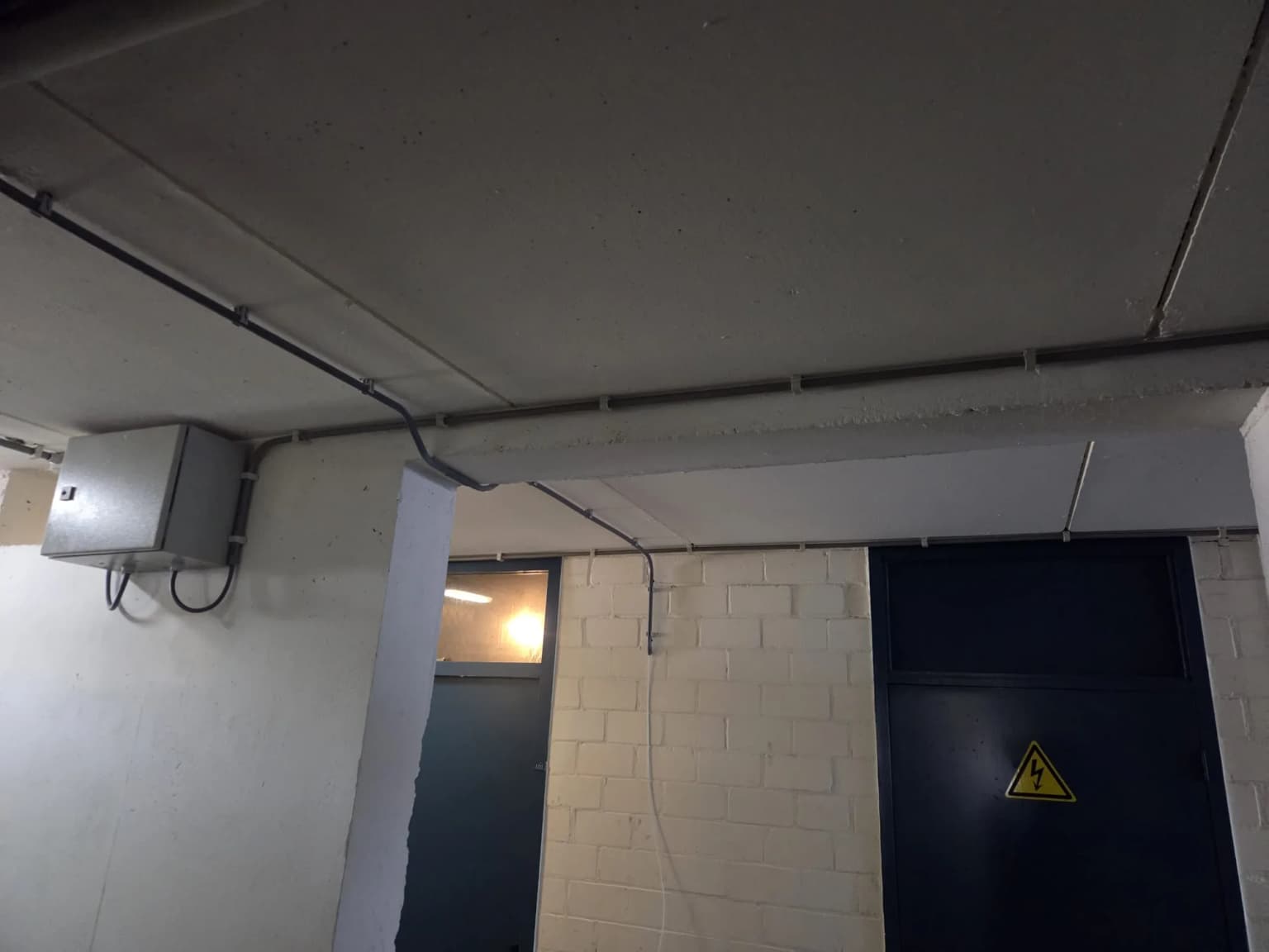 Bekabeling netjes in pijp weggewerkt langs het plafond bij de meterkast van het VvE-complex in Zwolle, zonder open bochten