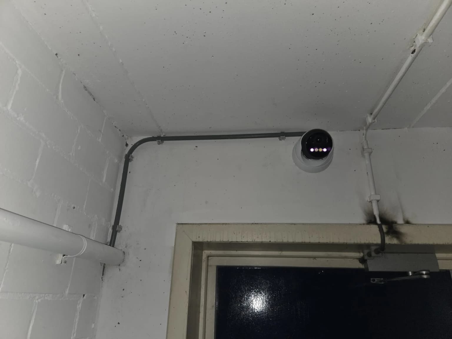 Vandaalbestendige dome-camera in de hoek van een gang bij het VvE-complex in Zwolle, met de infrarood-LED's zichtbaar