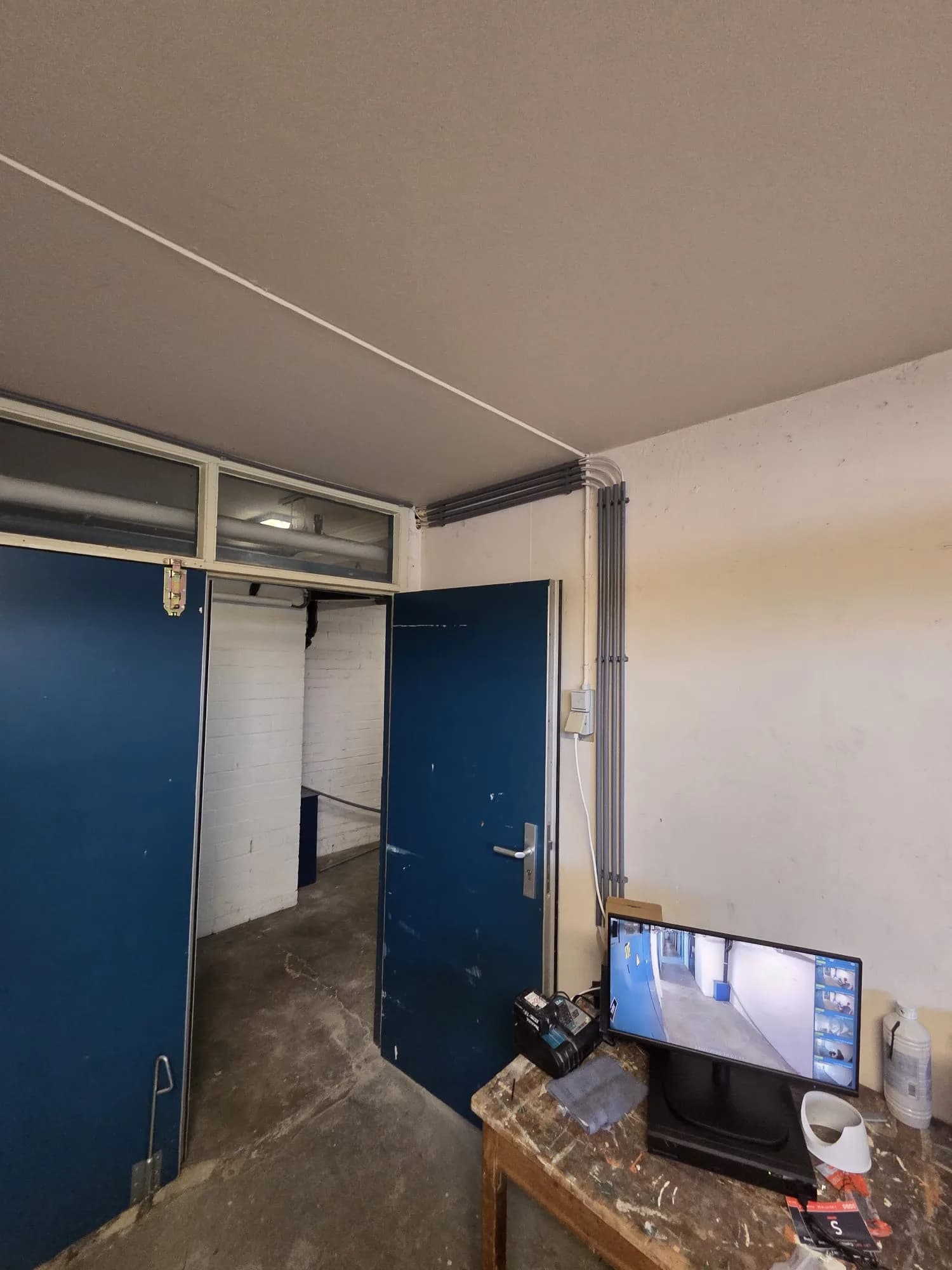 Monitor met live camerabeelden van meerdere gangen tijdens de installatie bij het VvE-complex in Zwolle