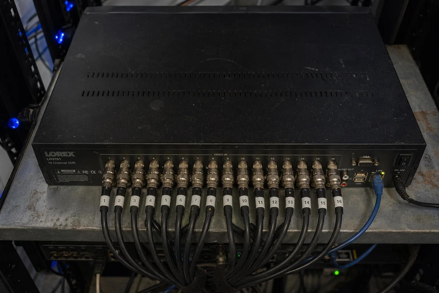 Oude analoge DVR met een rij BNC-connectoren en gelabelde coaxkabels